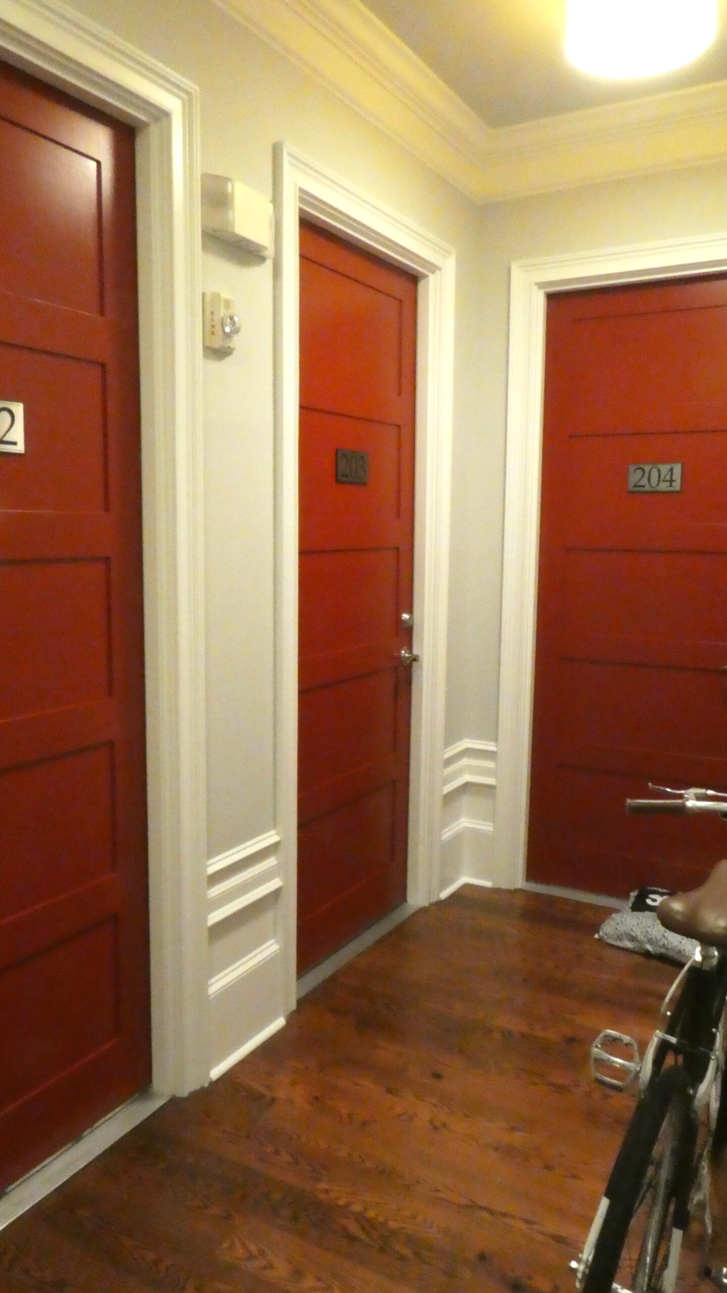 Second floor hallway showing red entry doors to individual units